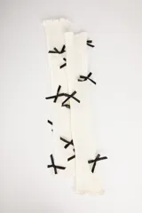 Calentadores de punto color crema con detalle de lazos negros.