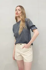 Short de algodón color beige, con diseño clásico de cinco bolsillos, tiro medio y terminación recta.