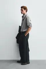 Pantalón de corte balloon fit confeccionado en una mezcla de lyocell y algodón. Presenta cierre frontal con cremallera y botón, bolsillos laterales y bolsillos traseros de vivo.