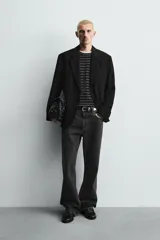 Blazer de corte relajado confeccionada en tejido fluido con mezcla de viscosa. Presenta cuello con solapas de muesca, manga larga con puños abotonados, bolsillos de solapa en la cadera y cierre frontal con botones.