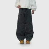 Pantalón de jean estilo ultra baggy, color negro con efecto lavado. Presenta un diseño de corte amplio con costuras reforzadas y detalles de bordes desflecados en los bolsillos laterales tipo cargo.