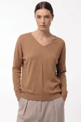 Sweater de punto con cuello en V, manga larga con puños acanalados y diseño de silueta relajada.