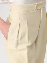 Pantalón sastrero color beige de lino, de tiro alto y corte recto.