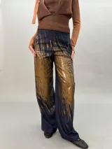 Pantalón de lana azul con estampado abstracto en tonos plateados. Tiro alto, corte amplio y bolsillos laterales ocultos.