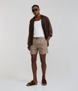 Bermuda de baño color beige, confeccionada en tejido ana ruga texturizado. Tiene lazo en la cintura, bolsillos laterales y un bolsillo trasero.