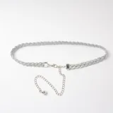 Cinto fino de estilo trenzado en color plateado, con cierre de mosquetón y cadena de alargue metálica terminada en una pequeña esfera.