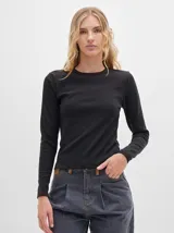 Remera de manga larga con cuello a la base, confeccionada en tejido acanalado con calce al cuerpo y diseño tipo crop.