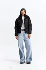 Campera puffer negra con cuello alto, cierre frontal y bolsillos laterales con cierre. Diseño acolchado de volumen medio.