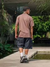 Remera de jersey con efecto teñido, color marrón, de corte holgado y cuello redondo. Presenta un estampado frontal con texto en tonos más oscuros.