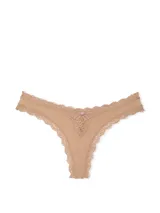 Bombacha tipo tanga de color praline, confeccionada en tela ultrasuave con delicados detalles de encaje en los bordes y un aplique central.