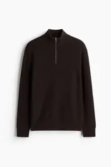 Buzo marrón de punto suave de algodón, con cuello elevado y medio cierre frontal, mangas largas y corte regular.