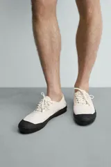Zapatilla de cordones confeccionada en tejido de algodón, con puntera reforzada en goma y suela de plataforma negra.