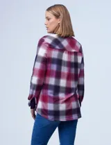 Camisa de tejido soft con estampado de cuadros en tonos rojizos y violetas. Presenta cuello camisero, cierre frontal con botones, mangas largas con presilla para regular el largo y dos bolsillos aplicados en el frente.