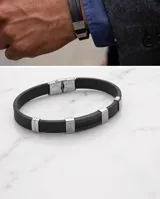Pulsera de goma negra con detalles en acero inoxidable plateado que incluyen apliques con diseño de guarda griega y cierre de seguridad.