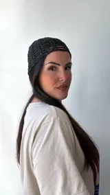 Gorro tipo beanie negro de tejido de red con detalles brillantes.