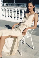 Vestido midi de viscosa con tejido jacquard, escote recto y tirantes finos cruzados en la espalda. Presenta un diseño fluido con abertura lateral en el bajo y cierre de cremallera en la espalda.