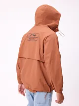 Campera impermeable Rusty con capucha, confeccionada en nylon. Presenta cierre frontal con botones a presión, bolsillos delanteros con solapa y puños elásticos.