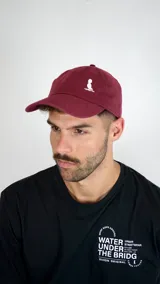 Gorra de béisbol color bordó con logo bordado en blanco en la parte frontal.