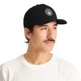 Gorro negro tipo trucker con paneles frontales rígidos y paneles traseros de malla. Presenta visera curva y parche bordado con el logo de Roark en el frente.