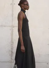 Top de punto fino color negro, con diseño entallado, sin mangas y cuello halter.