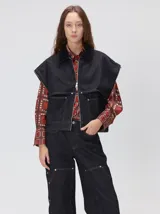 Campera de denim a rayas verticales con cuello de pana en color bordó. Presenta cierre frontal, mangas desmontables con cierre en los hombros, canesú en el pecho y bolsillos de parche cuadrados.