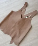 Chaleco de cuero color beige con breteles finos y escote en V.