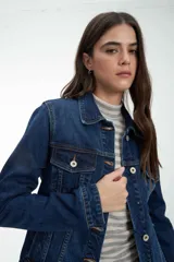 Campera de jean azul oscuro con botones metálicos plateados, cuello clásico y bolsillos con solapa en el pecho.