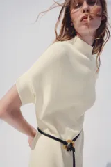Vestido midi de punto color azul marino, de corte holgado, con cuello subido y manga corta vuelta. Incluye un cinturón fino efecto piel con hebilla metálica dorada.