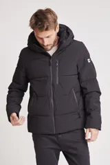 Cazadora acolchada tipo puffer color verde militar, con capucha desmontable, cierre frontal y bolsillos laterales con cierre.