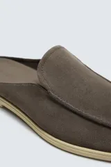 Mocasín destalonado de hombre, fabricado en piel con acabado serraje (gamuza), de horma redonda y suela a contraste con ligero tacón.