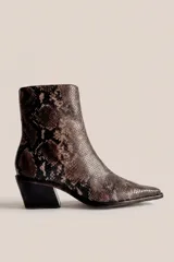 Botas de cuero con estampado animal print de serpiente, caña media, punta fina y tacón ancho.