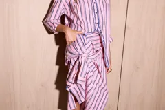 Camisa holgada de popelina de algodón a rayas verticales rosas, grises y azules. Presenta una abertura frontal con ribete festoneado en color azul marino y botones oscuros.