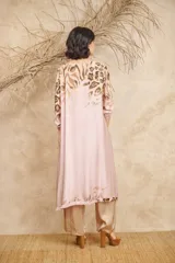 Túnica de satén color rosa pálido con estampado animal print en tonos marrones, corte asimétrico, terminaciones desflecadas y botones de coco.