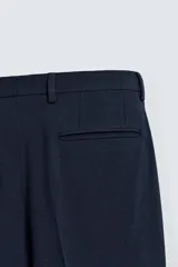 Pantalón de vestir de corte slim fit, confeccionado en tejido con viscosa. Presenta bolsillos frontales, bolsillos traseros de doble vivo con botón y cierre frontal con cremallera y botón.