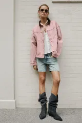 Cazadora de denim efecto lavado color rosado, con cuello solapa de pana marrón, cierre frontal con botones metálicos y bolsillos delanteros de plastrón.