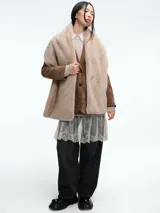 Blazer de pana color marrón con solapas clásicas, cierre frontal de dos botones y bolsillos laterales con solapa.