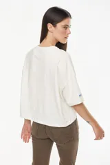 Remera de algodón con elastano, de moldería boxy y calce relajado, color blanco. Presenta un bordado exclusivo de un atardecer en tonos azules en el pecho.