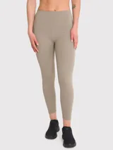 Calza deportiva color beige, tiro alto, con bolsillos laterales y banda de silicona en la cintura.