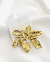 Par de aros colgantes con forma de flor dorada con textura acanalada.