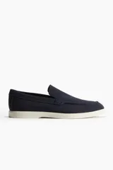 Mocasines de gamuza azul marino con costura tradicional en la parte frontal y suela de goma blanca.