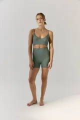 Top deportivo verde con escote en V, tejido en morley sin costuras, con breteles regulables y logo del Drop a contratono en la espalda.