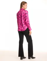 Camisa de satén con estampado de rectángulos negros sobre fondo blanco. Presenta cuello clásico con solapa, cierre frontal con botones metálicos y mangas largas con puños rectos.