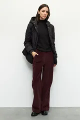 Campera puffer color tostado con capucha, cierre frontal con botones a presión y bolsillos laterales. Presenta diseño acolchado, puños elásticos y ajuste en la cintura.