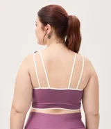 Top deportivo Get Over confeccionado en microfibra color violeta, con escote recto, copa incorporada, breteles anchos y bies contrastante en color blanco. Cuenta con banda acanalada en la base.