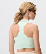 Top deportivo Get Over de microfibra seamless con textura acanalada, color verde menta, cuello polo con cierre frontal y detalles de líneas finas en el cuello.