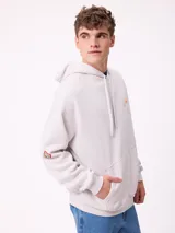 Canguro con capucha de color bordó, con diseño estampado en la espalda en tonos amarillos y blancos, y detalle de parche en la manga. Posee corte holgado y puños elásticos.