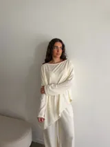 Conjunto gris melange compuesto por un buzo de cuello bote amplio y corte asimétrico con bolsillos, y un pantalón largo de corte recto y holgado.