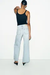 Jeans de tiro bajo con cinco bolsillos, pernera recta y detalle de costuras marcadas en la parte delantera. Cierre frontal con cremallera y botón.