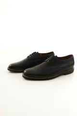 Zapato de vestir acordonado para hombre, confeccionado en 100% cuero vacuno negro con diseño clásico, punta redonda y suela con detalle de costura visible.