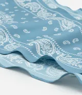 Pañuelo triangular de satén color celeste con estampado paisley en blanco.